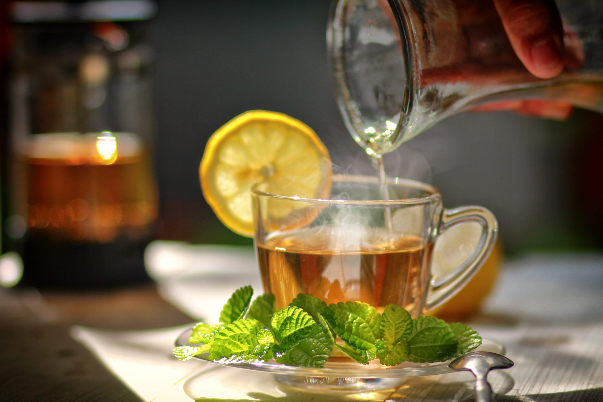 Glass teacup with mint and lemon slice.