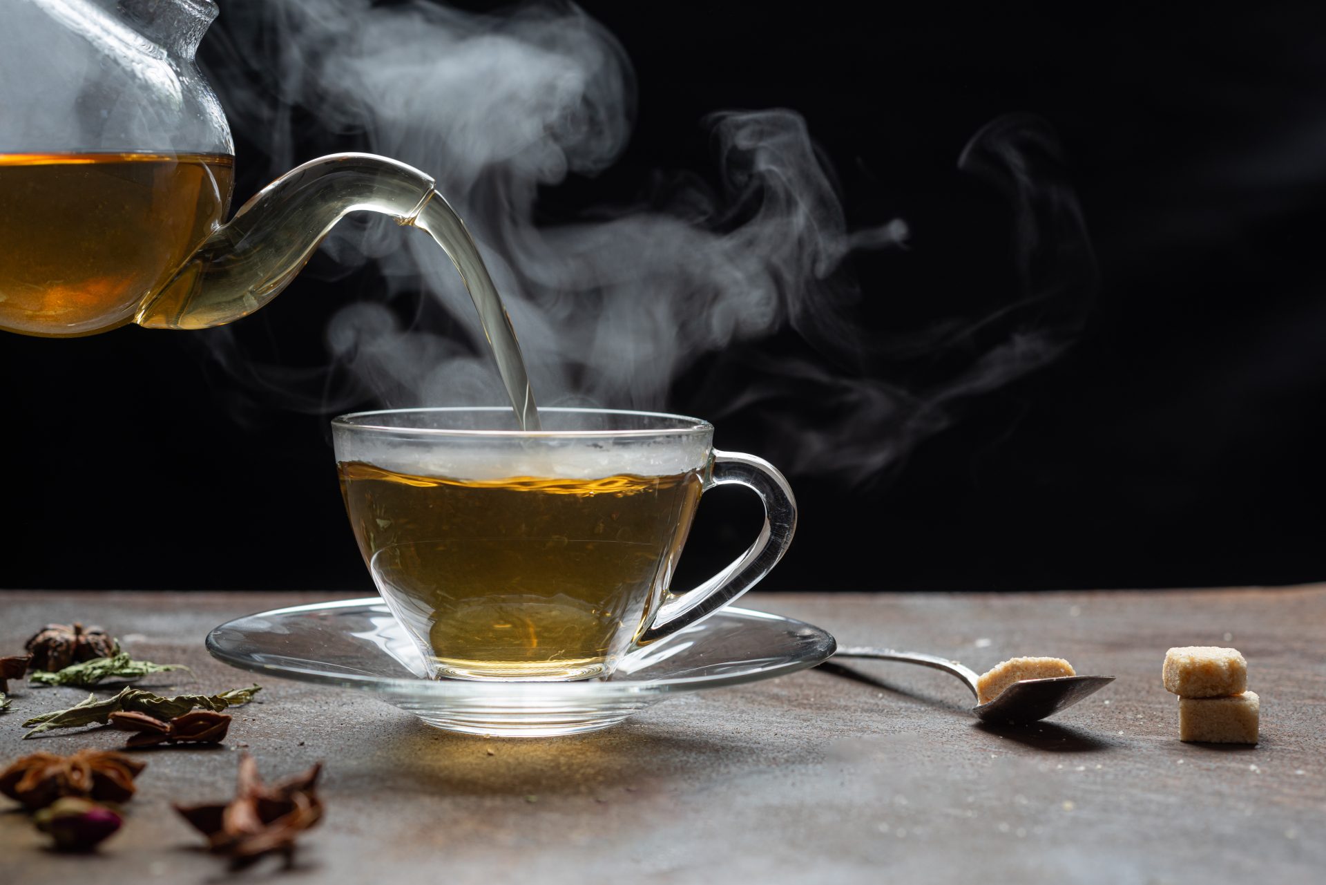Steaming tea poured beside sugar cubes.