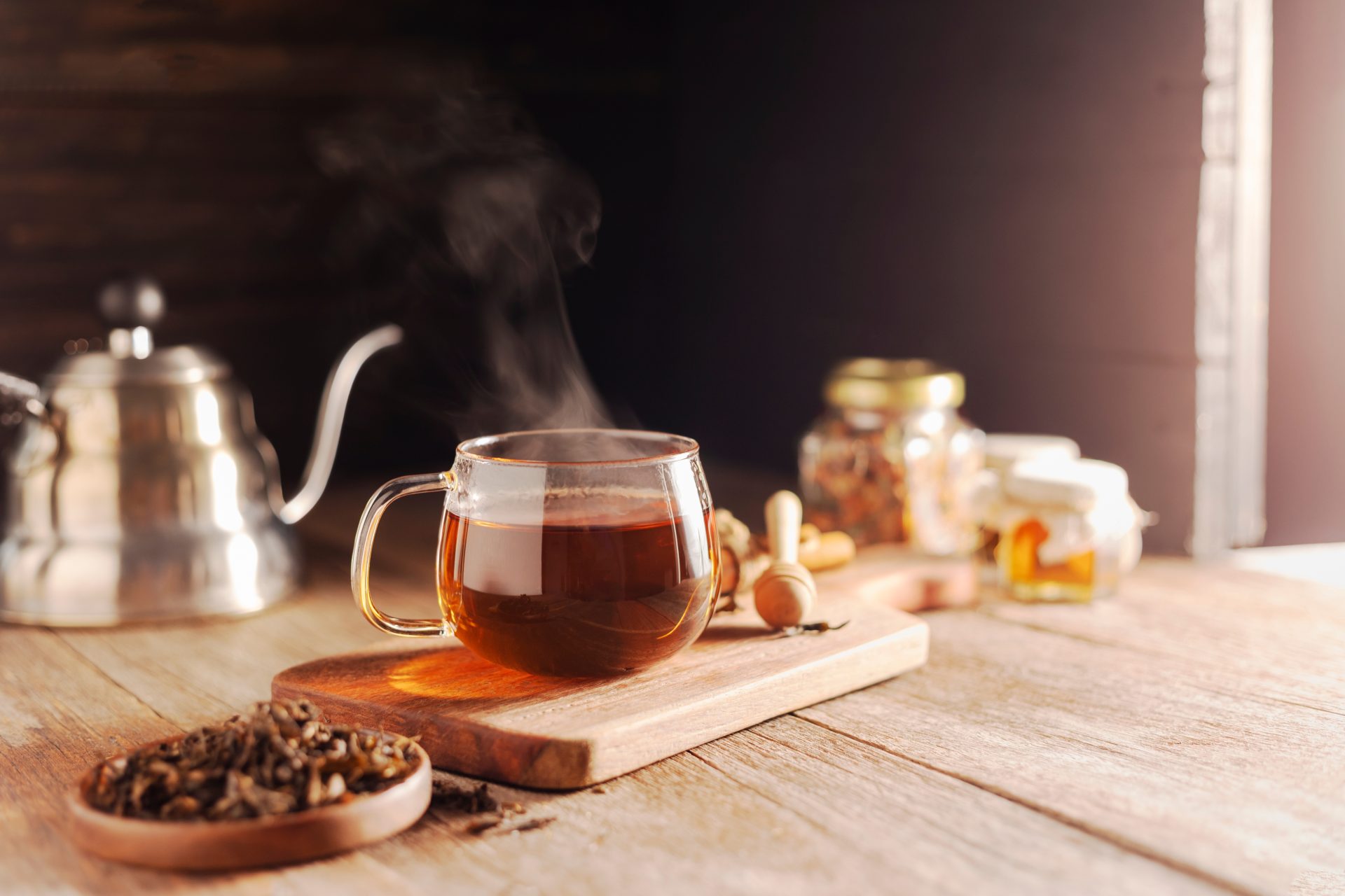 Steaming black tea with cozy rustic setup.